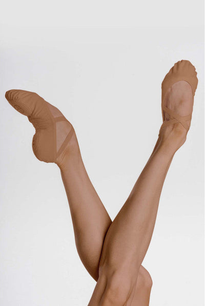A pair of bare feet wearing nude-colored ballet pointe shoes, posed in a V shape against a light gray background.