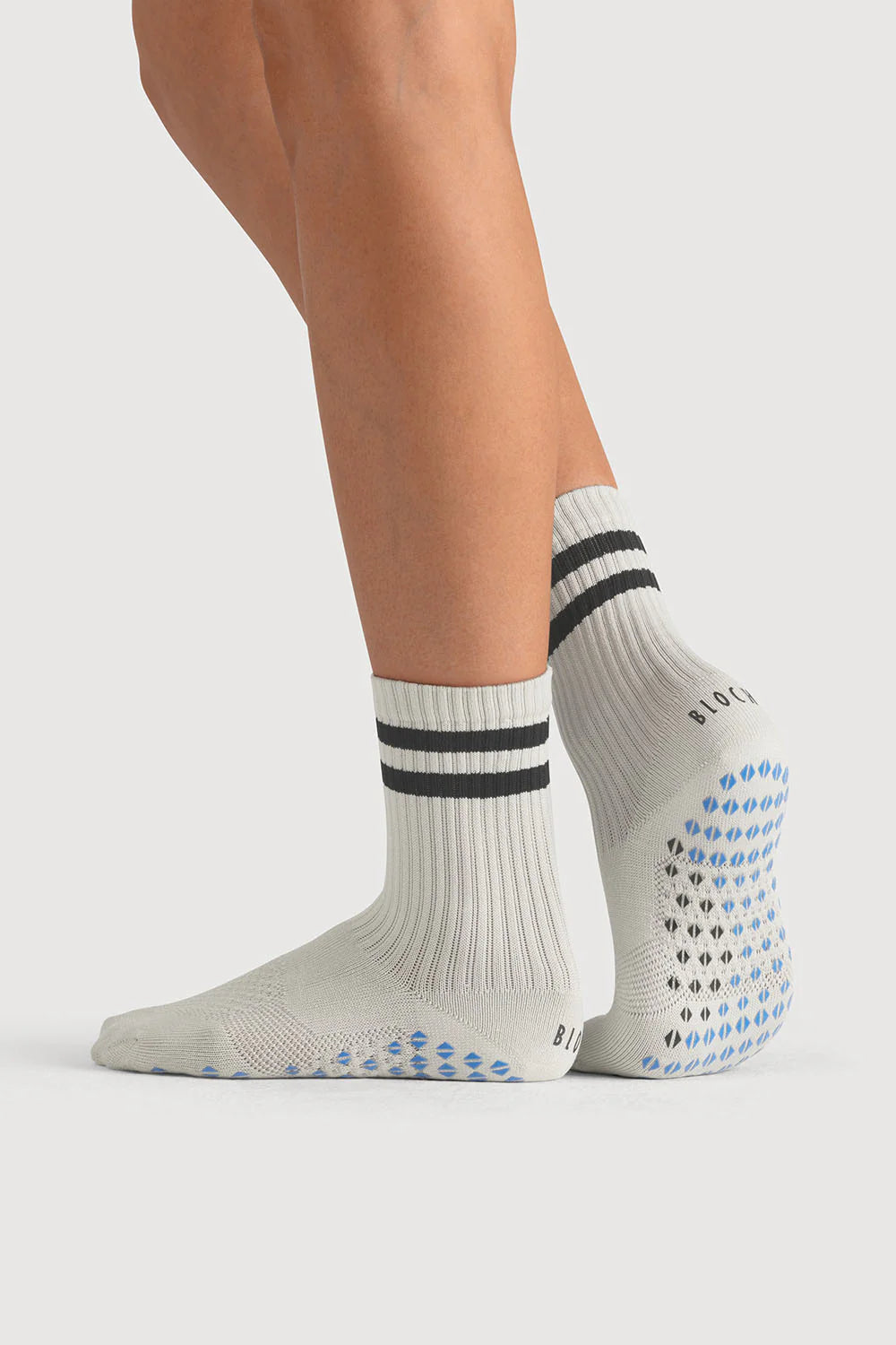 White socks with black stripes and blue patterns worn by a person on a white background