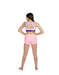 Woman wearing a pink sports bra and shorts set on a white background