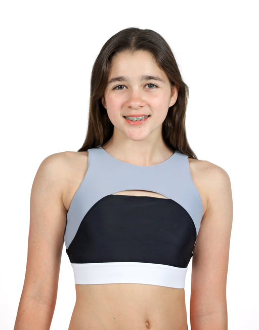 Young girl wearing a two-tone sports bra with a white background