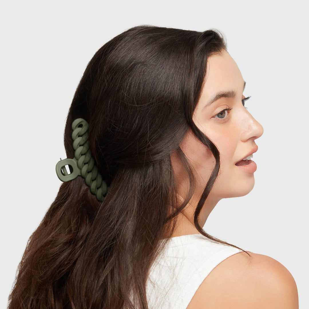 Woman with a green hair tie in her hair on a white background