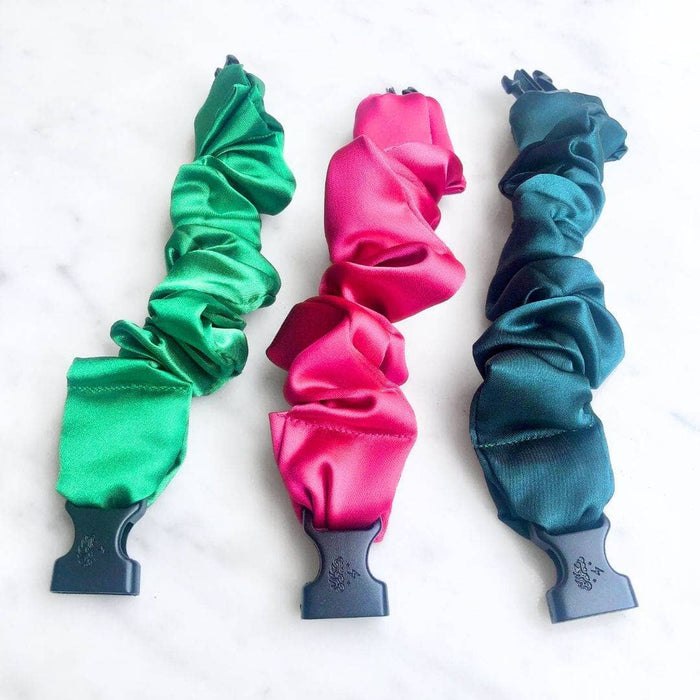 Three colorful scrunchies in green, pink, and blue on a white background