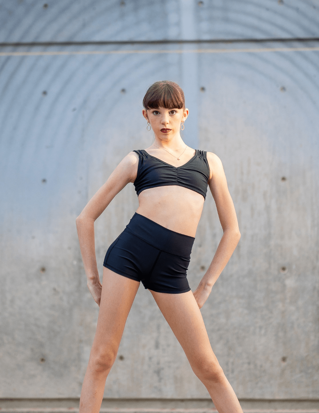 Person wearing a black athletic outfit against a neutral background