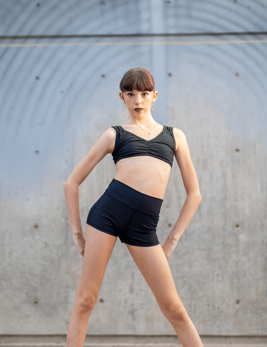 Person wearing a black athletic outfit against a neutral background