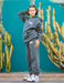 Person wearing a gray hoodie and pants with visible branding, standing in front of cacti.