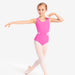 Young girl in a pink leotard and white tights posing on a white background