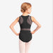 Young girl wearing a black ballet leotard with mesh panels on a white background