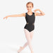 Young girl in a black leotard and white tights posing on a white background