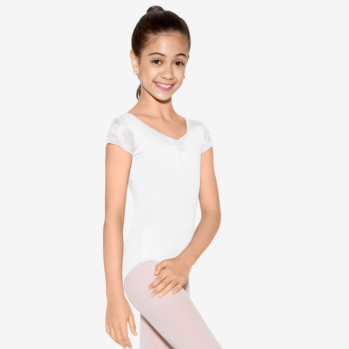 Young girl wearing a white leotard and pink tights on a white background