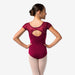 Ballerina wearing a maroon leotard on a white background