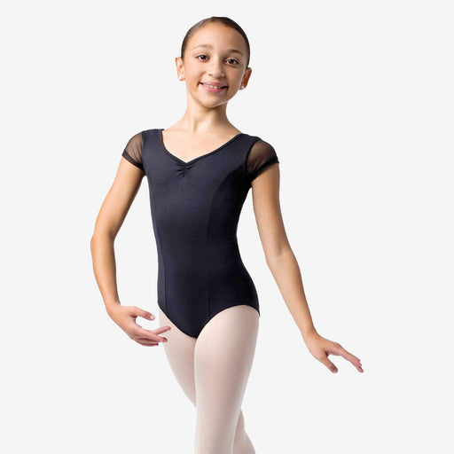 Young dancer wearing a black leotard and white tights on a white background
