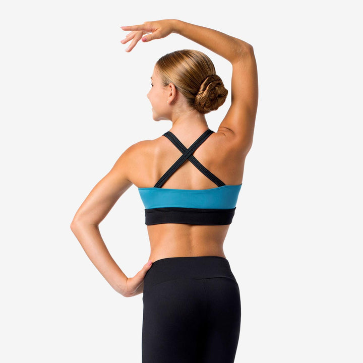Woman wearing a blue and black sports bra and leggings on a white background
