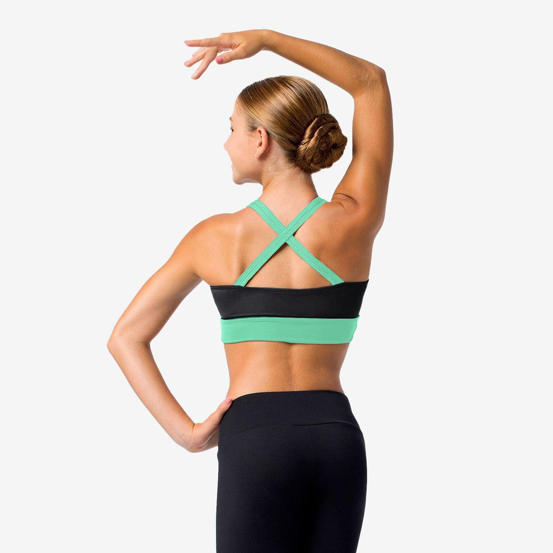 Woman wearing a green and black sports bra on a white background