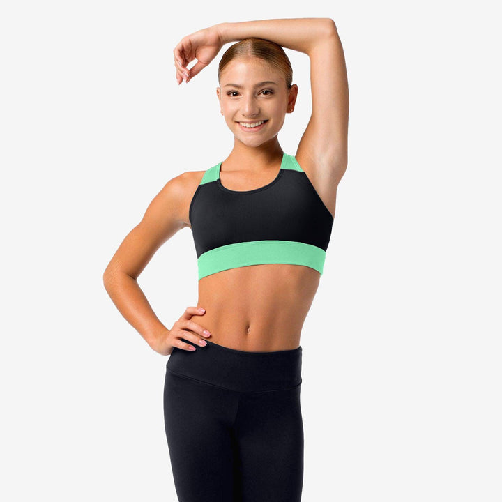 Woman wearing a black and green sports bra and leggings on a white background