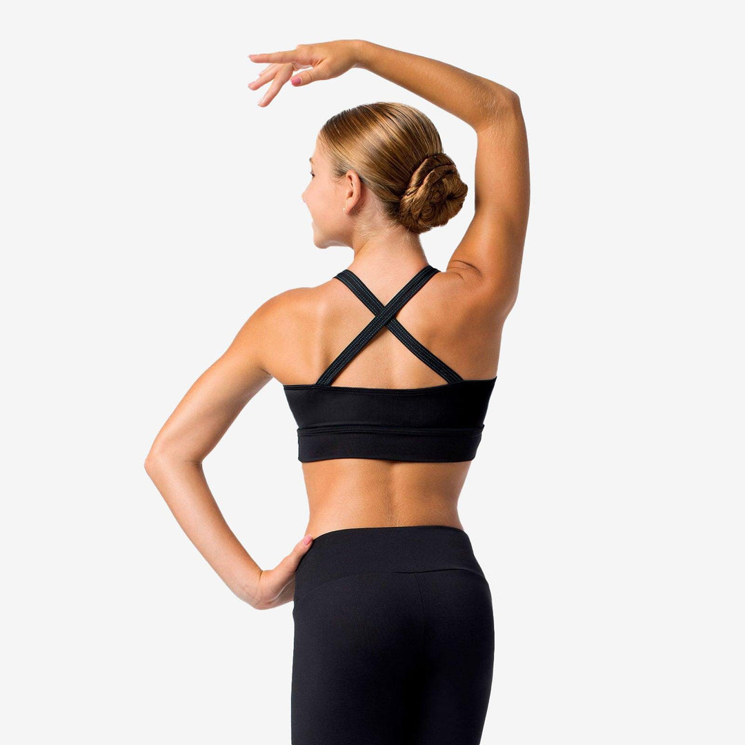 Woman wearing a black sports bra and leggings on a white background