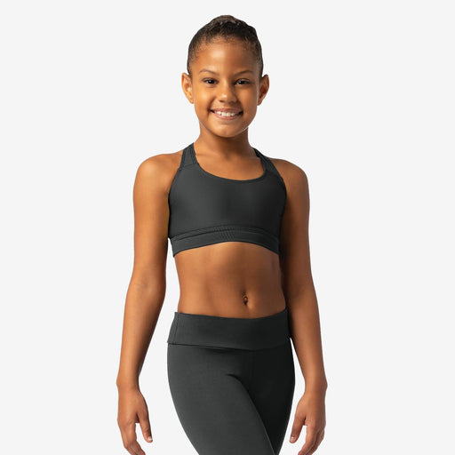 Young woman wearing a black sports bra and leggings on a white background