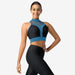 Woman wearing a black and blue sports bra and leggings on a white background
