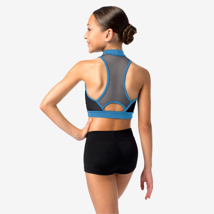 Woman wearing a gray and blue sports bra with black shorts on a white background