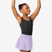Young girl in a black leotard and lavender skirt posing with arms raised on a white background