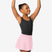 Young girl in a black tank top and pink skirt posing with arms raised on a white background