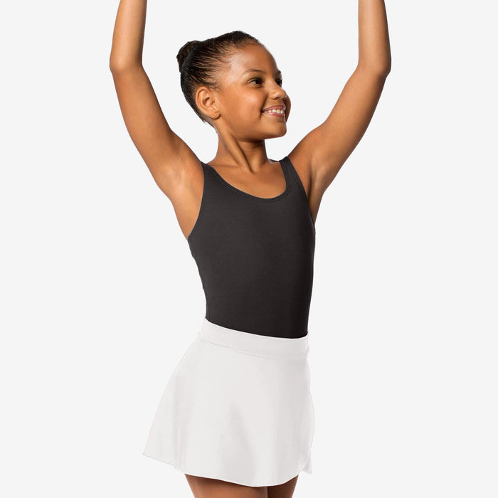 Young girl in a black tank top and white skirt with arms raised against a white background