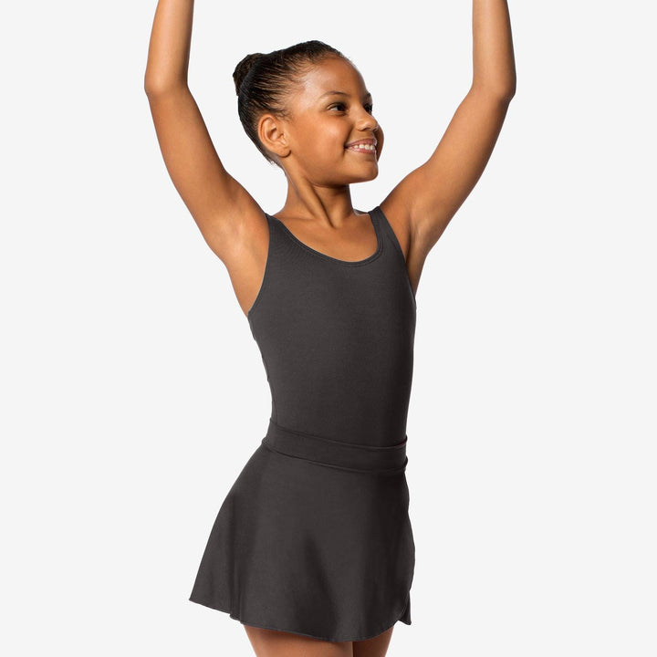 Young girl in a black dress with arms raised against a white background
