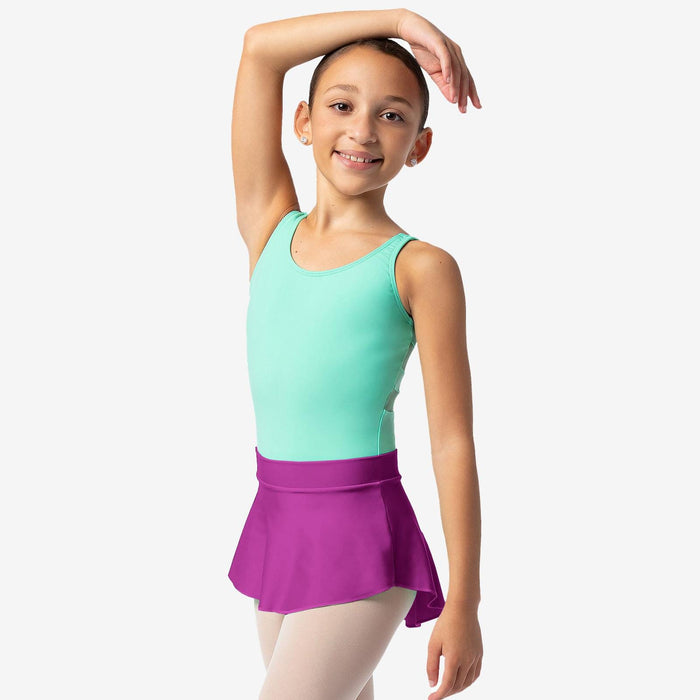 Young girl in a green top and purple skirt posing against a white background