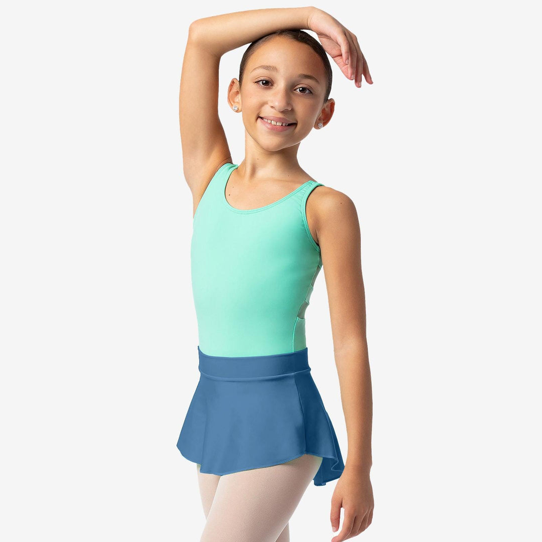 Young girl in a green tank top and blue skirt posing against a white background