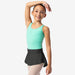 Young girl in a green leotard and black skirt posing against a white background