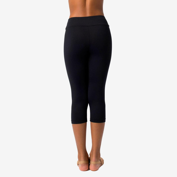 Black capri leggings worn by a person on a white background