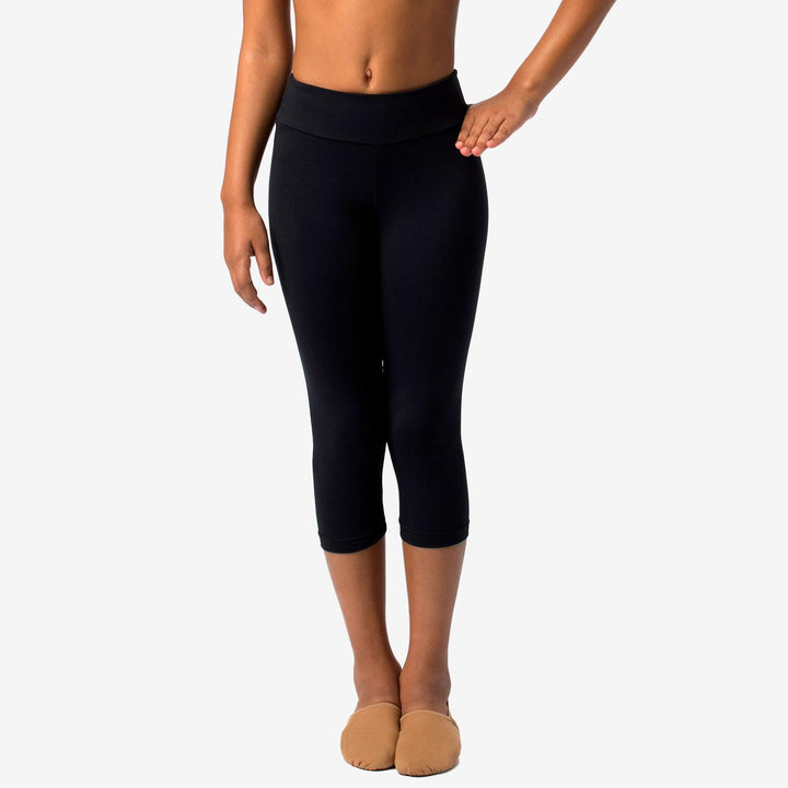 Person wearing black capri leggings on a white background