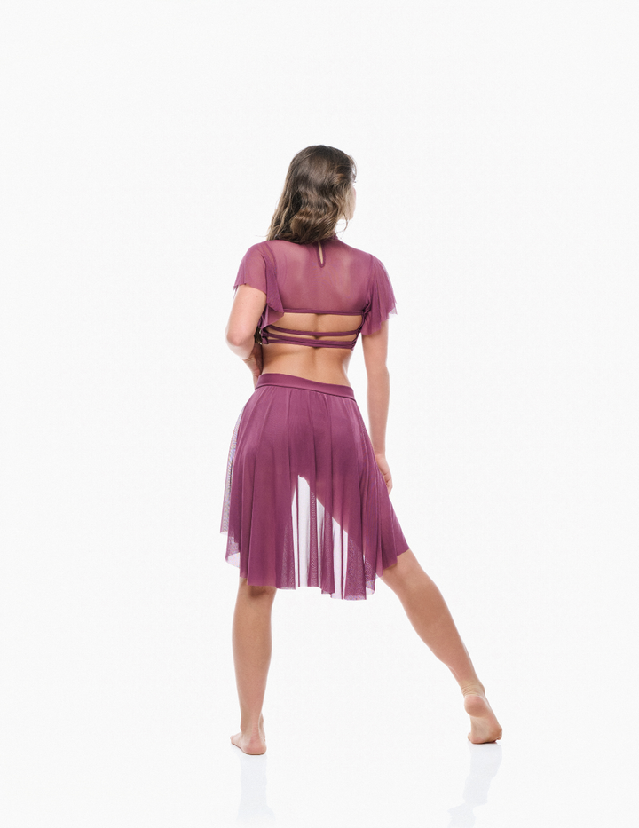 Woman wearing a purple outfit with a sheer top and skirt on a white background