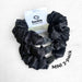 Black scrunchies with a 'buckle' brand card on a white background