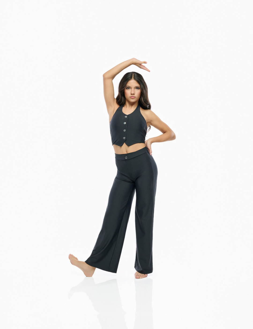 A woman modeling a dark charcoal gray two-piece lounge set consisting of a sleeveless cropped tank top with buttons and matching wide-leg pants, posed against a seamless white studio background.