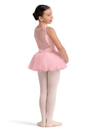 Young girl in a pink ballet outfit standing on a white background