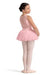 Young girl in a pink ballet outfit standing on a white background