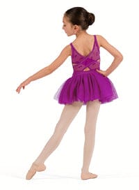 Young girl in a purple ballet outfit posing on a white background