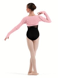 Ballerina in a pink top and black leotard posing on a white background