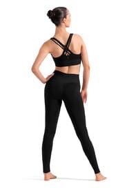 Woman wearing a black sports bra and leggings on a white background
