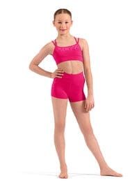 Young girl wearing a pink sports bra and shorts on a white background