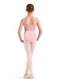 Young girl in a pink ballet outfit standing on a white background