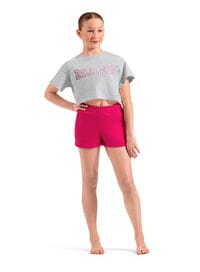 Person wearing a gray t-shirt with text and pink shorts on a white background