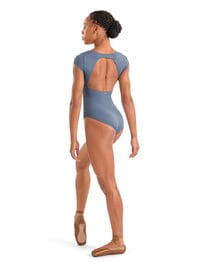 Dancer wearing a blue leotard with open back on a white background