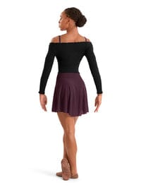 Person wearing a black long-sleeve top and maroon skirt on a white background