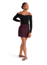Woman wearing a black long-sleeve top and purple skirt on a white background