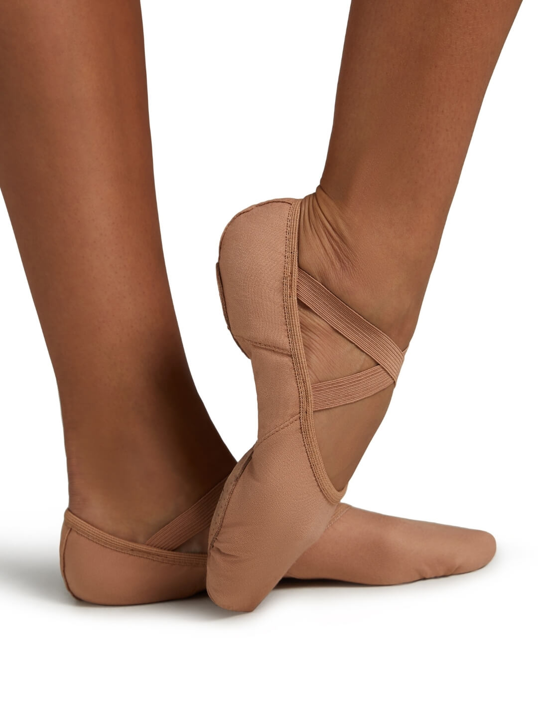 Brown ballet shoes worn on feet with a white background
