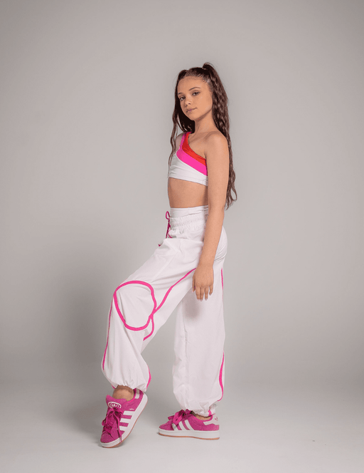 Person wearing a white outfit with pink accents on a gray background