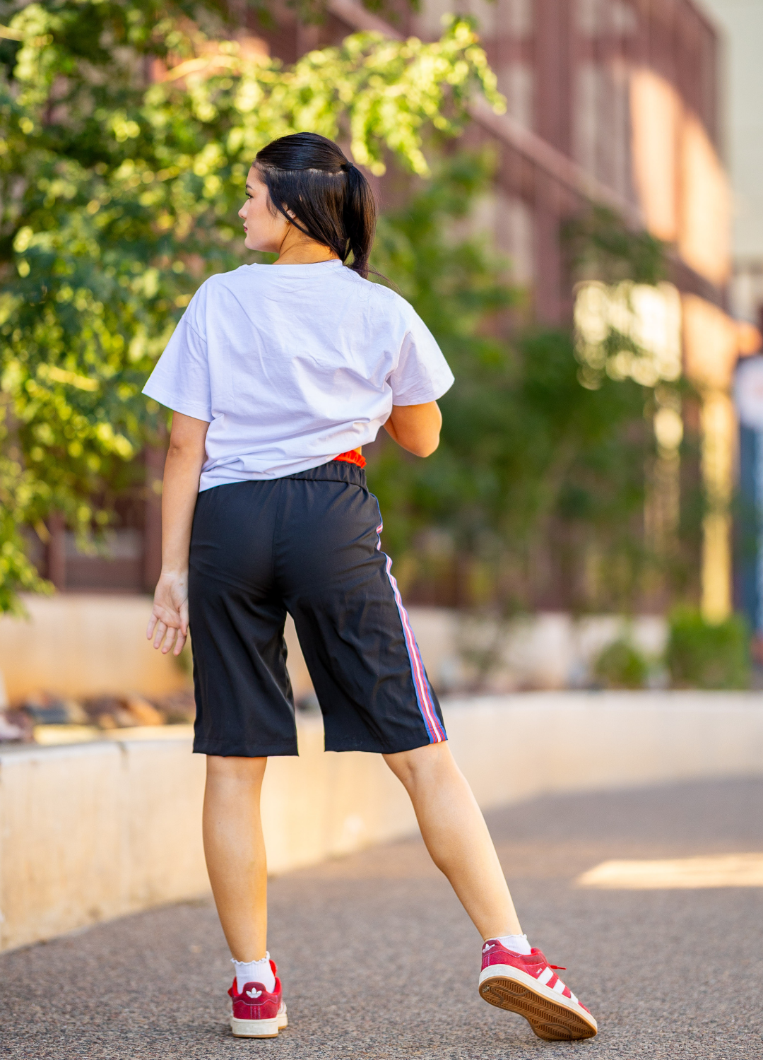 Back side of dancer on street in shorts and tshirt