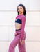 Woman wearing a pink athletic outfit with a white wall background