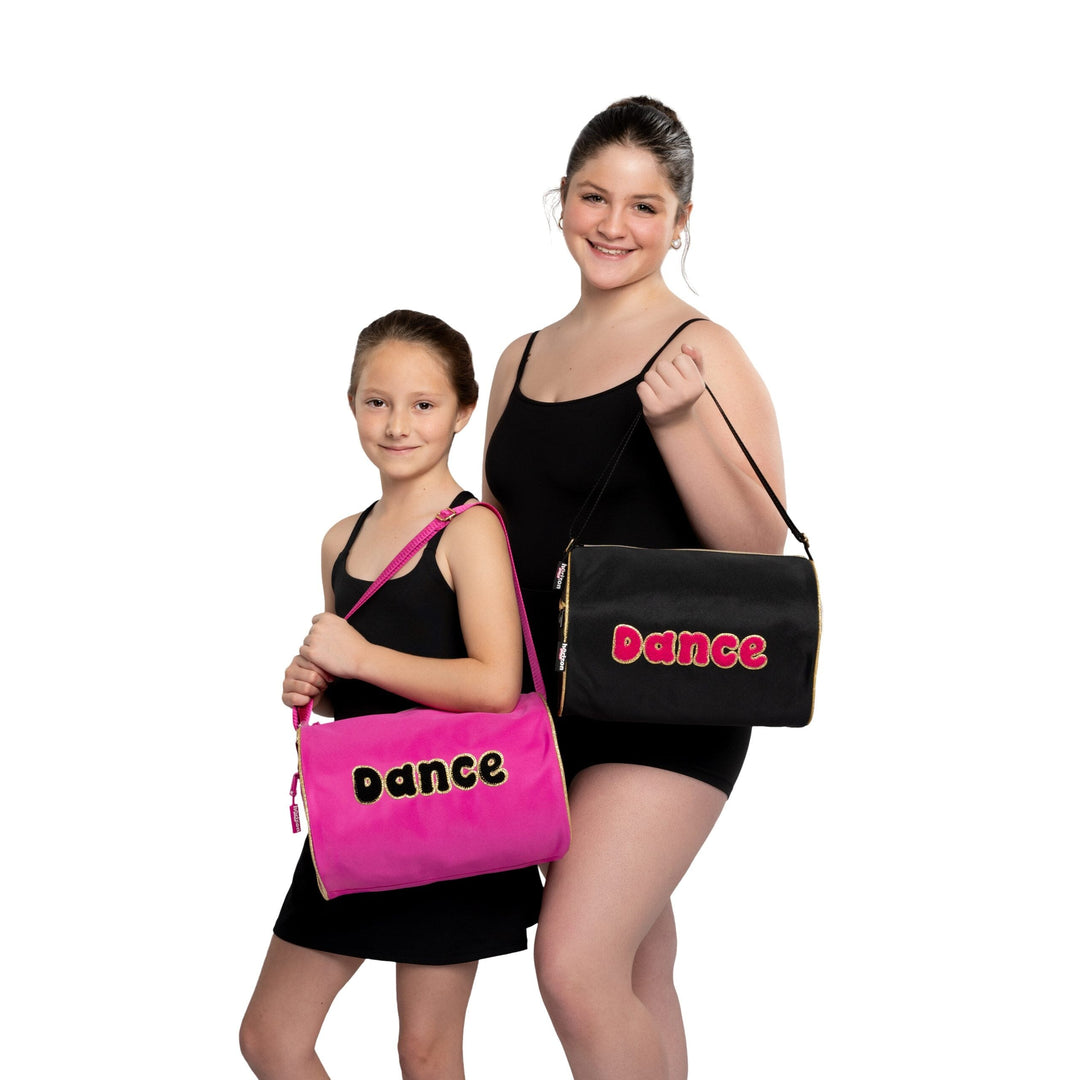 Two children holding dance bags with 'Dance' written on them against a white background